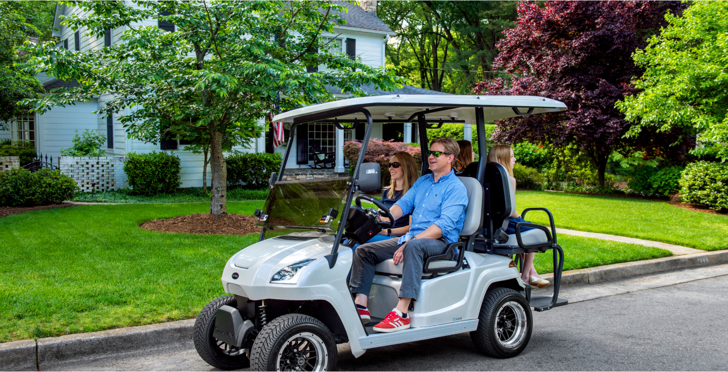 Family enjoying a ride in a STAR EV golf cart in a residential neighborhood